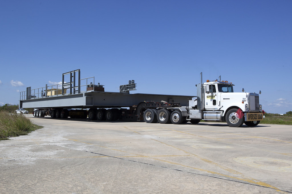 What type of equipment does a heavy hauling company have for transporting oversize or overweight loads?